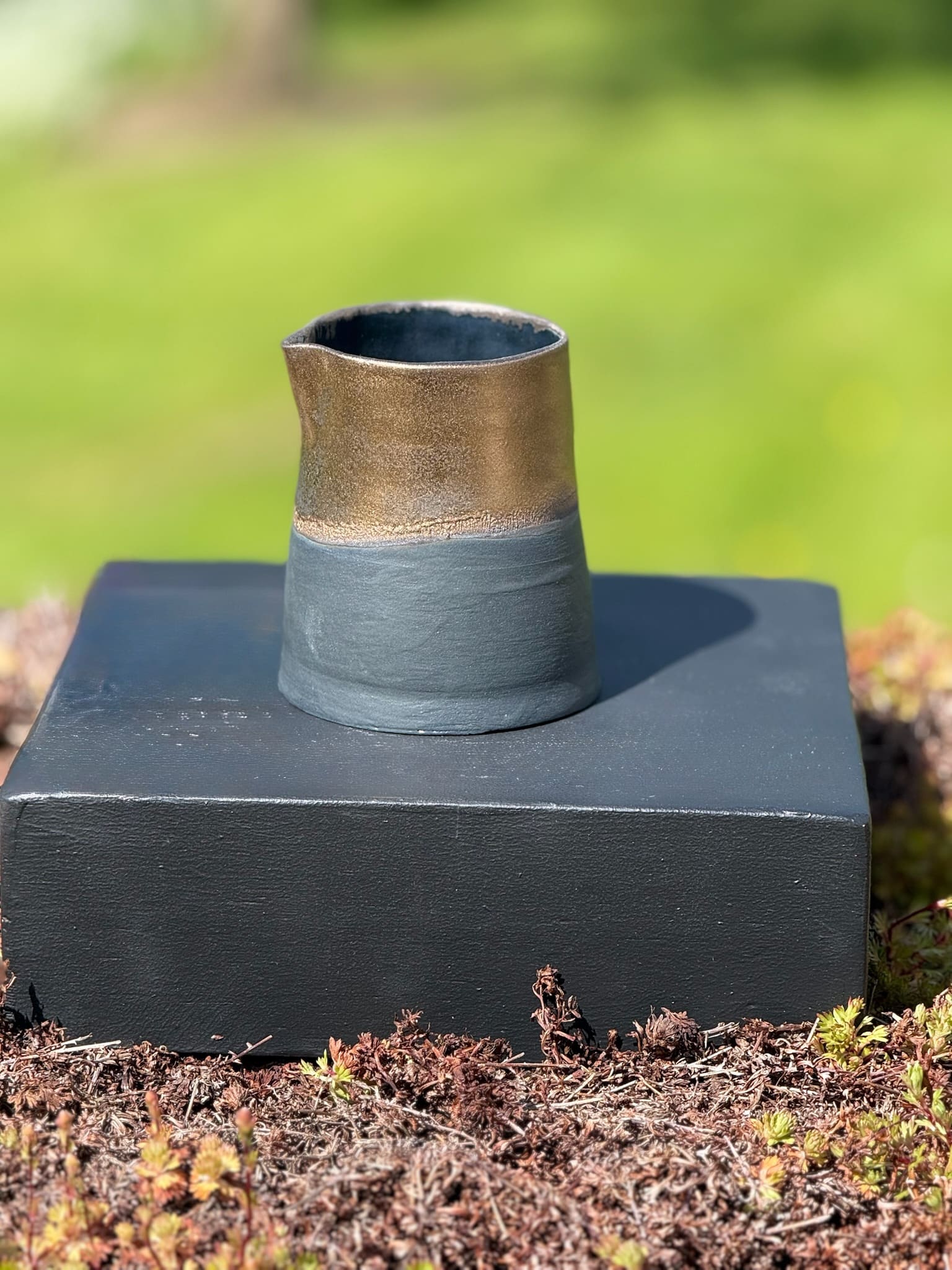 Bronze and black handleless pouring jug, detail