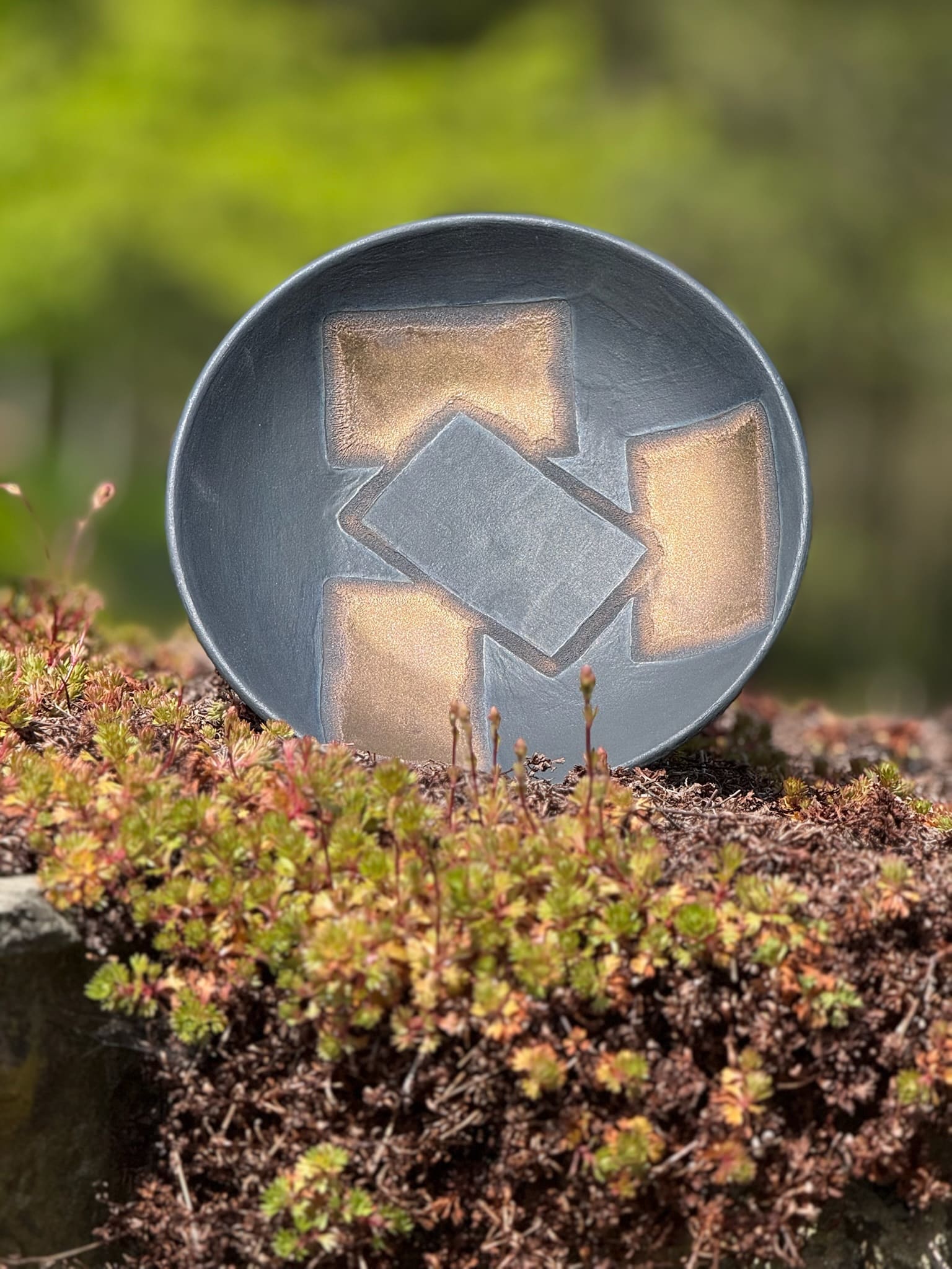 Bronze and black ornamental bowl with geometric inlay
