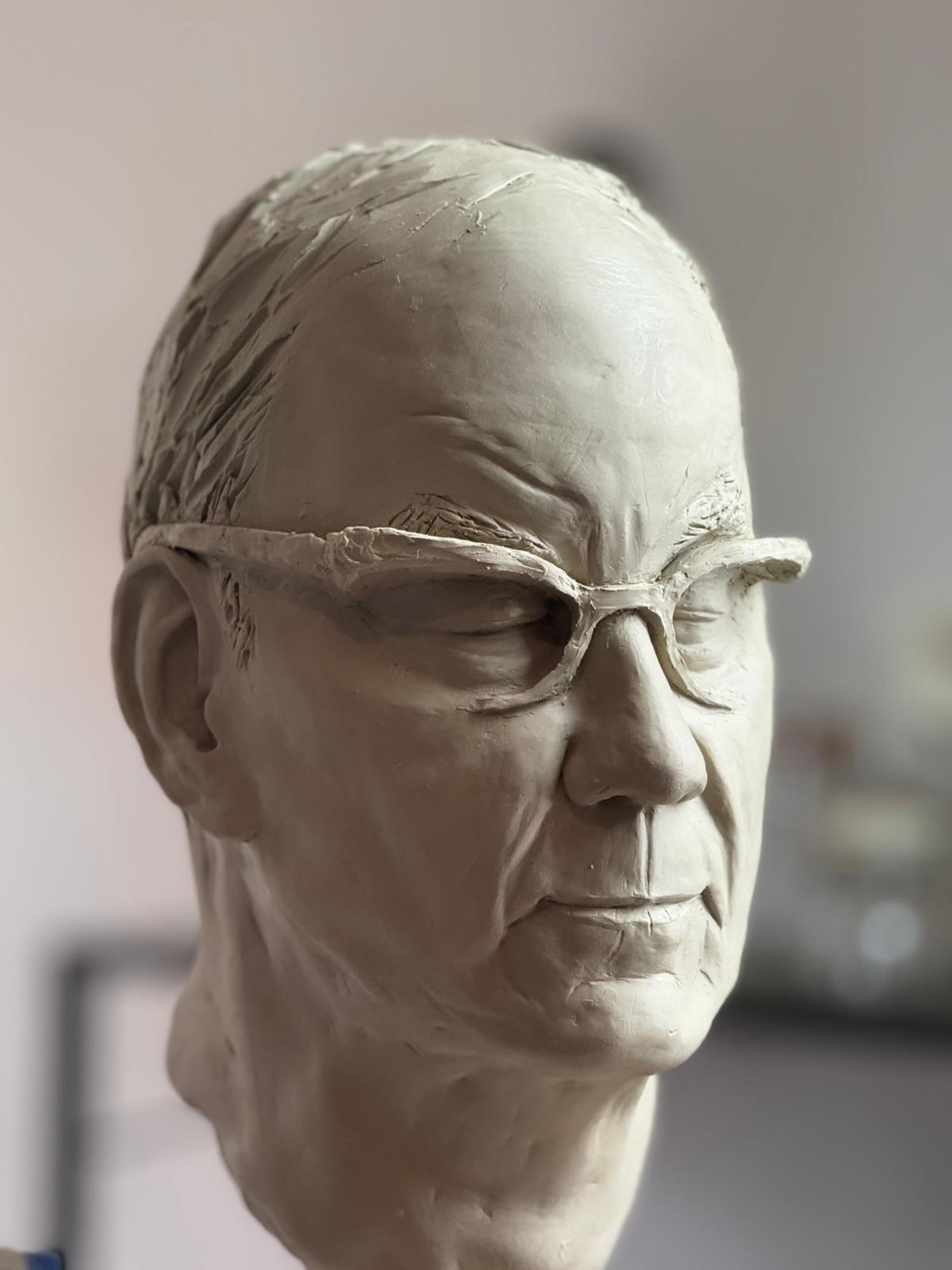 Clay portrait head of a man wearing spectacles, frontal view