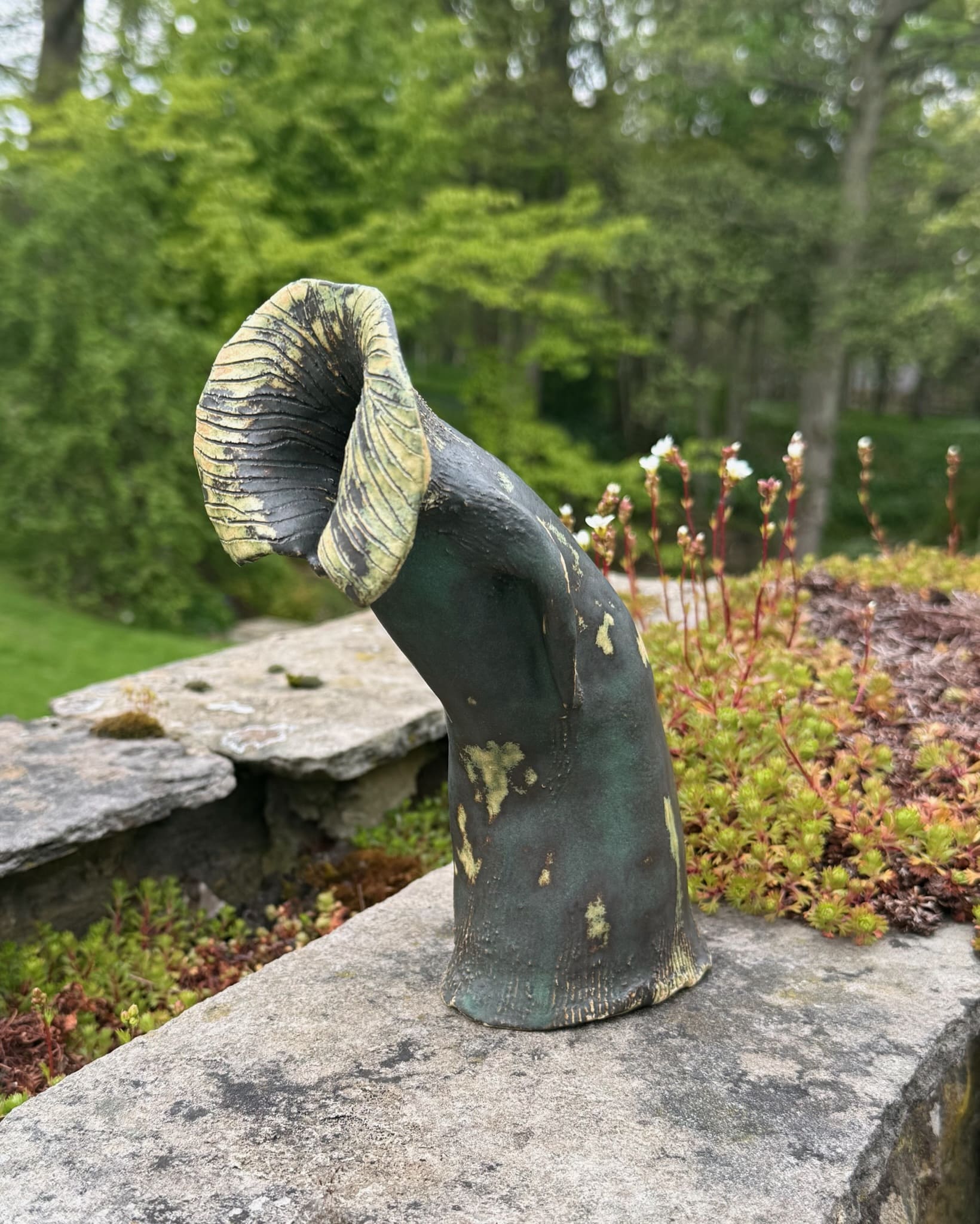 Abstract hooded ceramic form with furled crown, green glaze