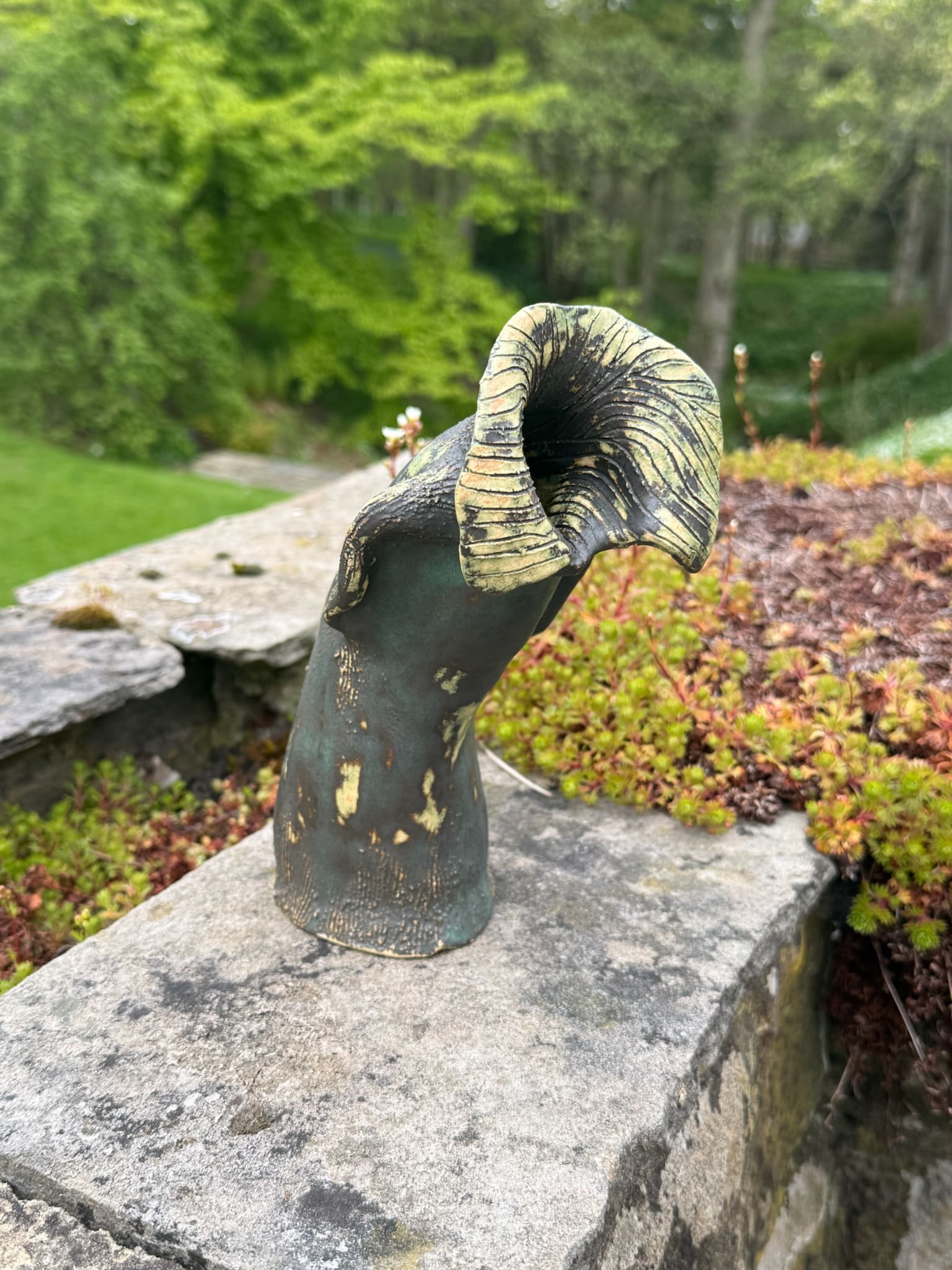 Abstract hooded ceramic form with open cowl, green glaze