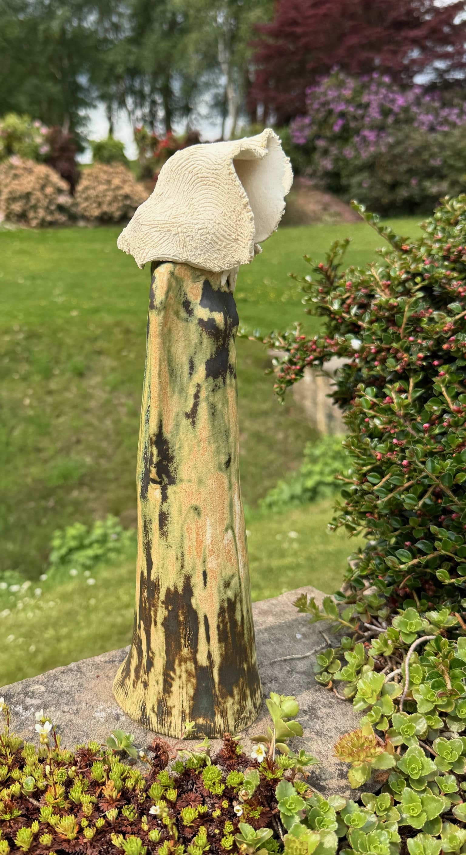 Hooded ceramic figure in profile, mottled green glaze