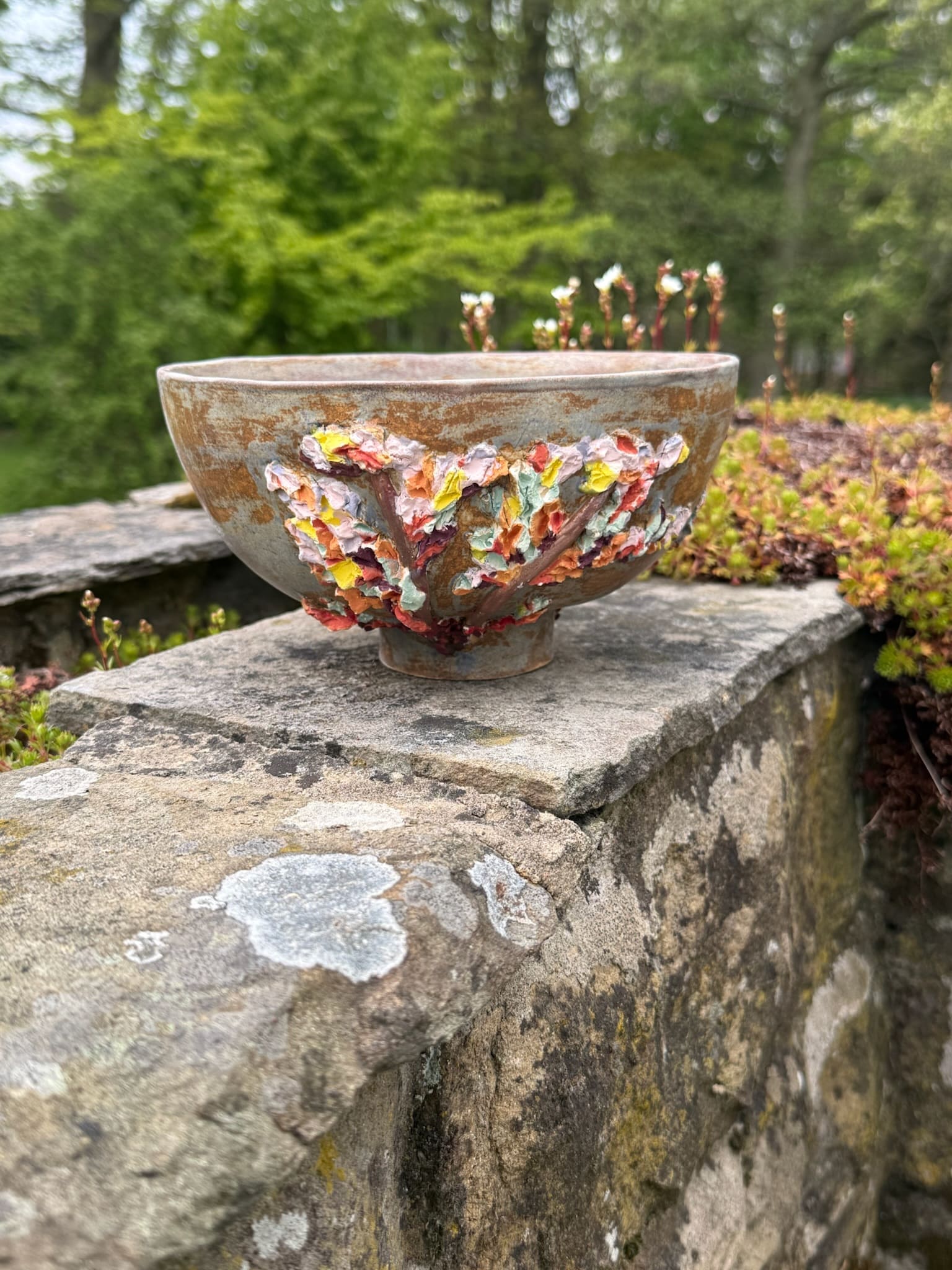 White ceramic sphere on plinth with a vivid colour seam, viewed from above